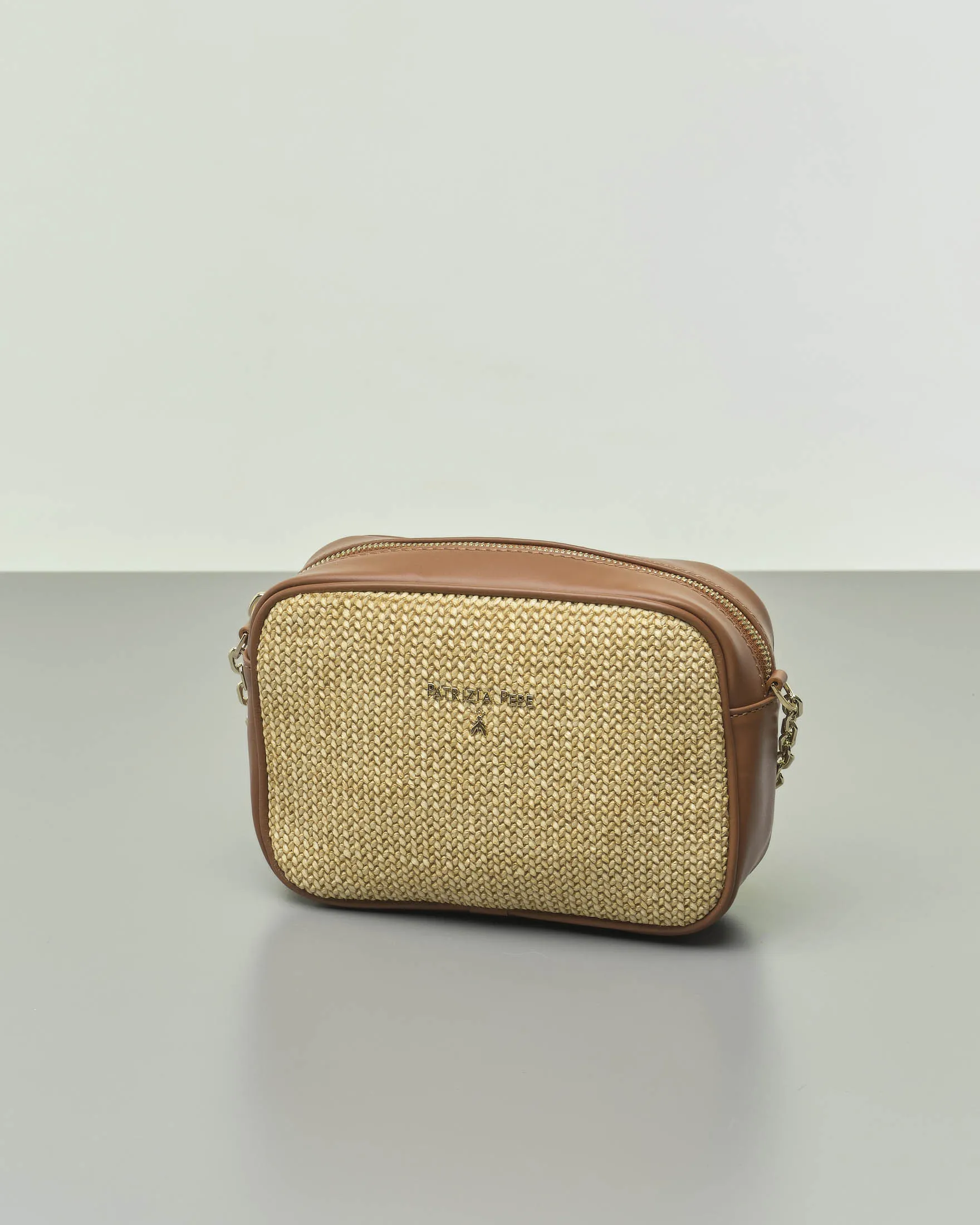 Cross bag effetto raffia naturale con profili in pelle color cuoio con tracolla abbinata con inserti a catena dorata