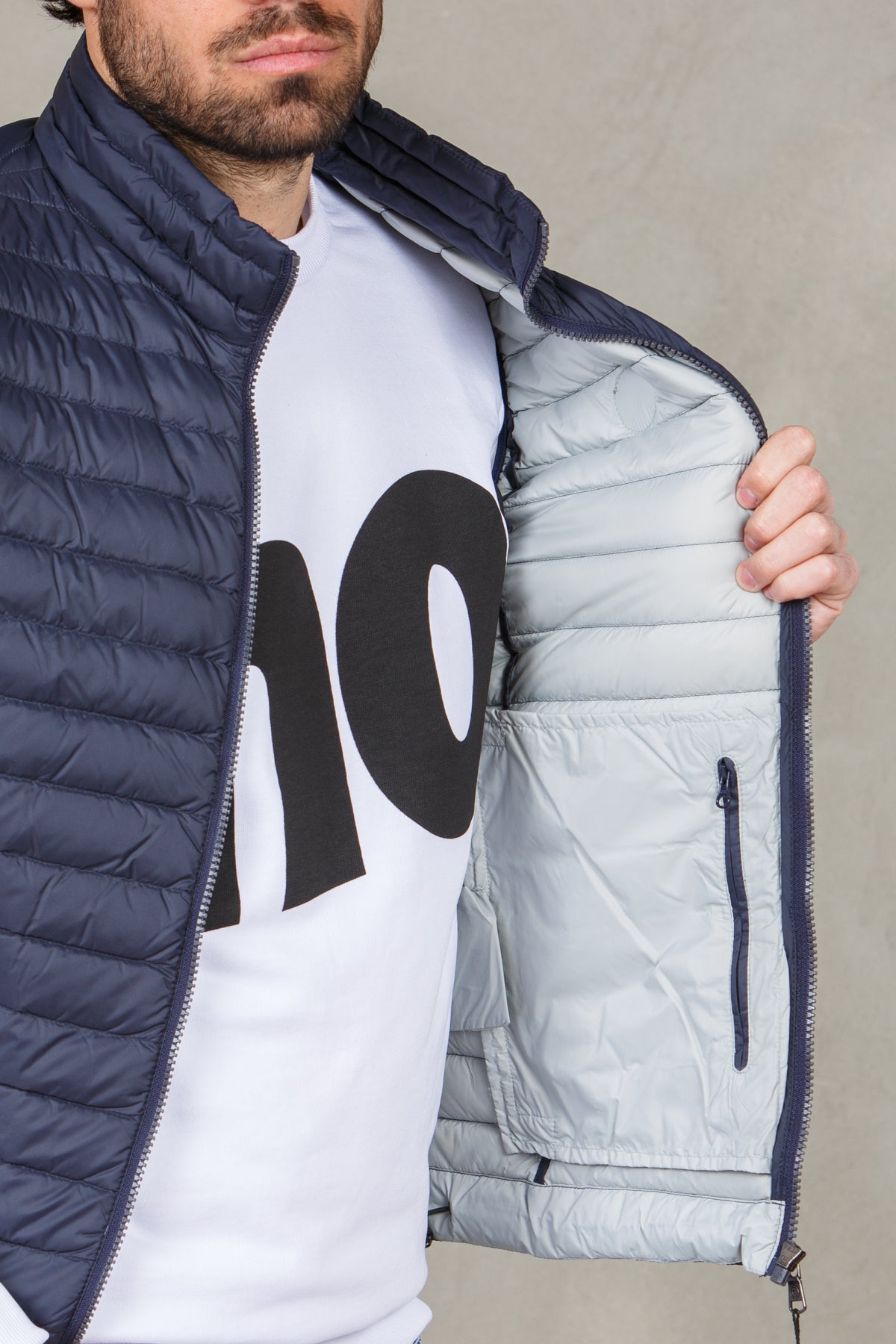 Gilet piumino urban chiusura con zip, tasche laterali e tasca interna con zip. Giromanica con nastro elastico, coulisse di regol