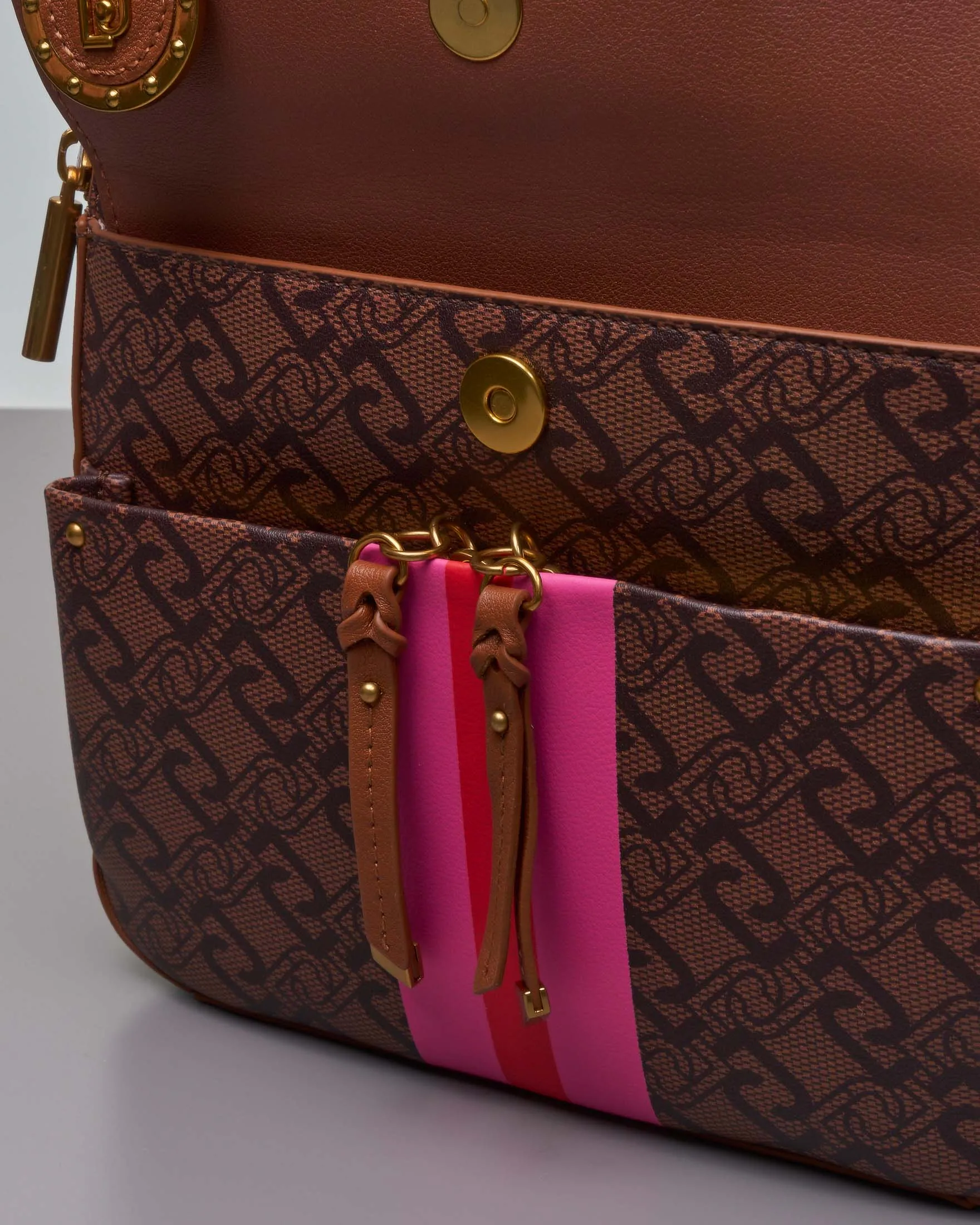 Zaino in similpelle color cuoio a fantasia monogram nera con patta a tinta unita con righe rosse e rosa centrali